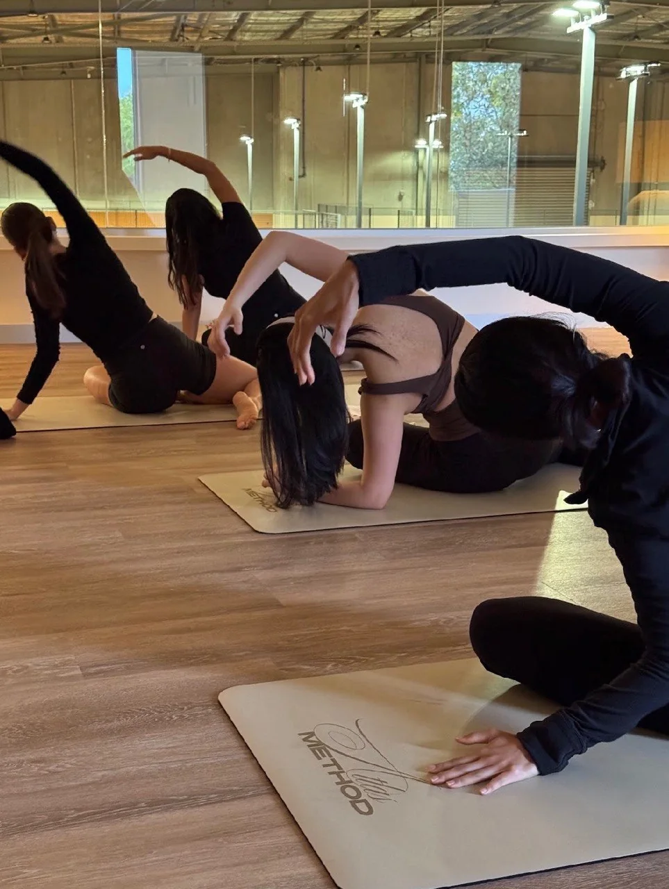 Group following a guided side stretch on Atlas mats