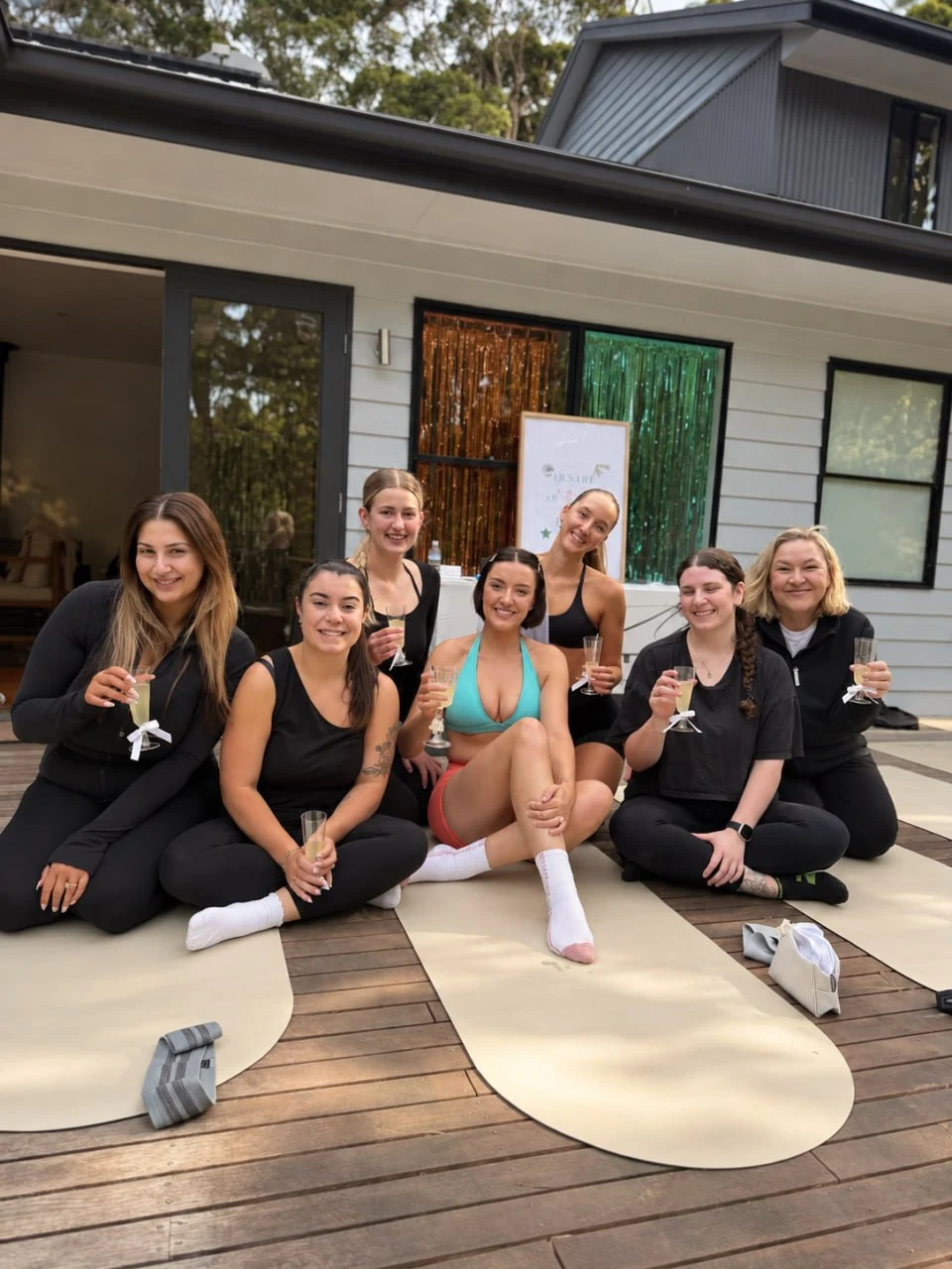 Group seated together on exercise mats outdoors