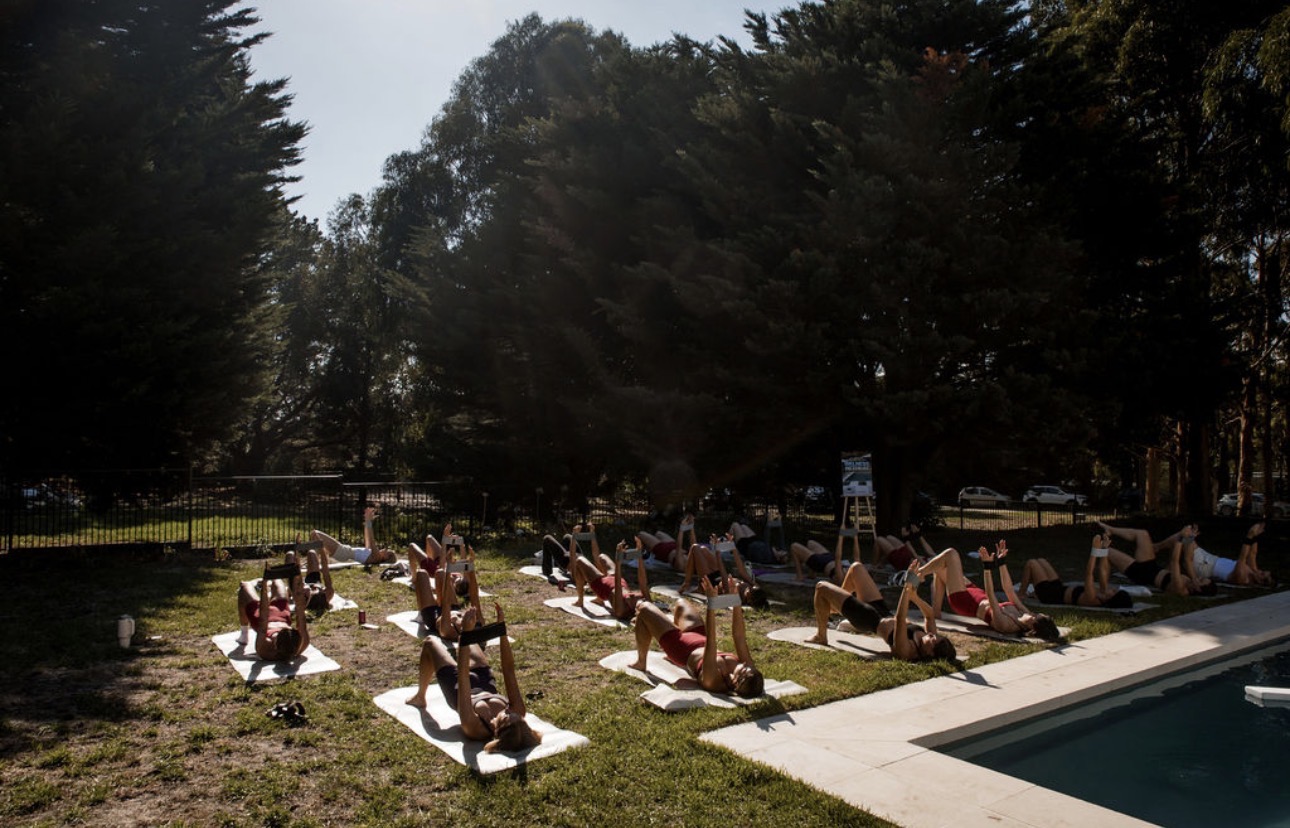 Group Pilates experience by a pool